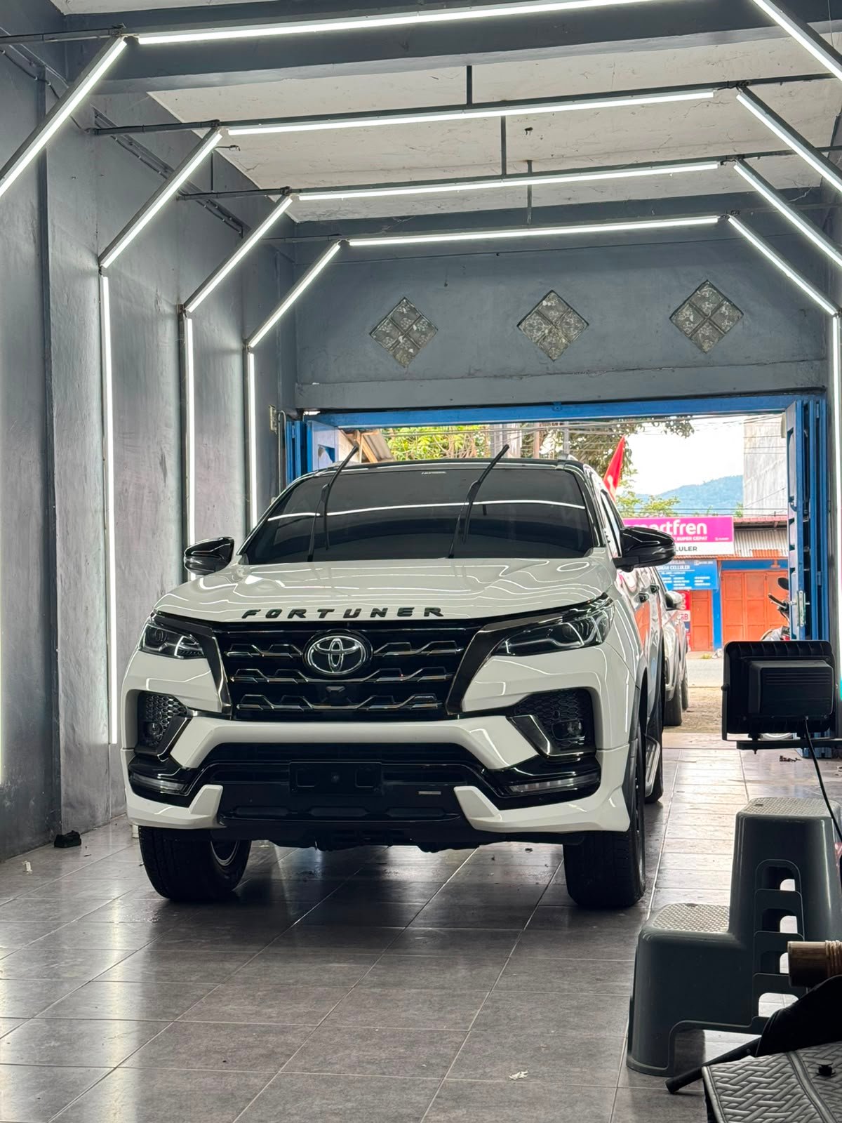 Teknisi melakukan coating pada mobil putih